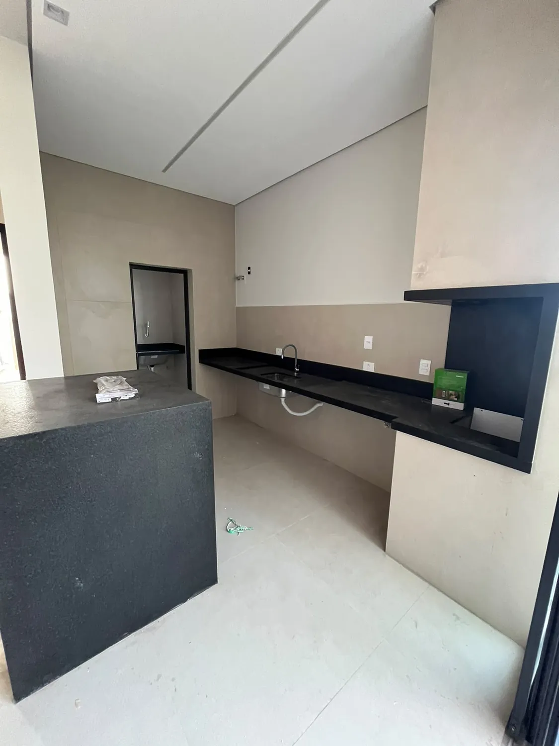 Cozinha com bancada de granito preto e parede clara